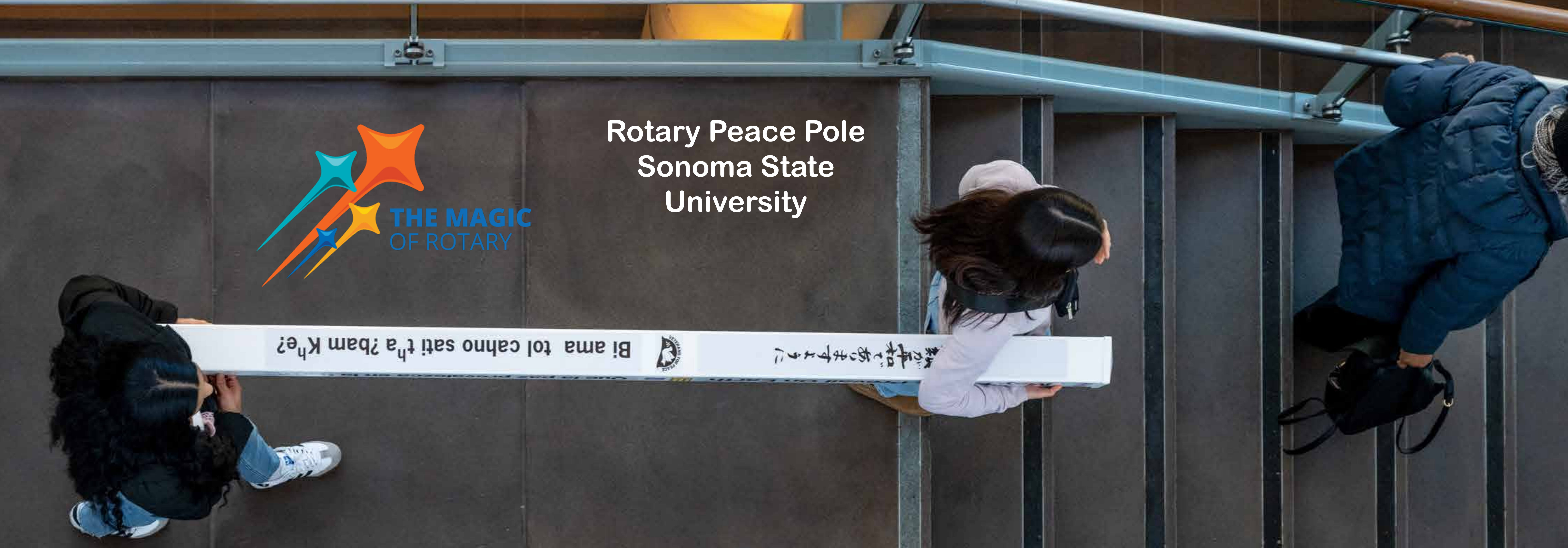students caring a peace pole to be installed on campus